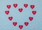 Valentine`s Day blue background with red and pearl hearts. Valentine greeting card. Flat lay style with copy space