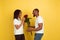 Valentine`s day celebration, happy african-american couple isolated on yellow background