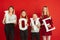 Valentine`s day celebration, happy caucasian teens holding letters on red background