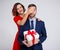 Valentine`s day, christmas or surprise concept - woman surprising her boyfriend with gift over white