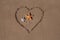 Valentine\'s day concept at beach. two starfish and drawn heart on sand texture.