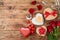 Valentine`s day concept with coffee cup, heart shape chocolate, rose flowers and gift boxes on wooden background