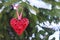 Valentine`s Day concept. Decorative wooden red heart on a snowy spruce branch with copy space. Selective focus. Symbol of love