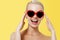 Valentine`s Day concept. Fashion Model girl isolated over yellow background. Beauty stylish blonde woman posing in heart