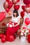 Valentine`s day concept - full length portrait of young woman sitting on vintage sofa and opening gift box with red heart-shaped