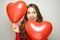 Valentine`s day concept. Lovely girl with heart shaped balloons on gray background.