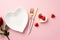 Valentine`s Day concept. Top view photo of heart shaped dish cutlery chocolate candies and rose on isolated pastel pink backgroun