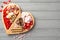 Valentine`s Day concept. Top view photo of wooden heart shaped serving tray with sweets plate chocolate jelly candies and cookies