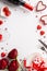 Valentine`s Day concept. Top view vertical photo of wine bottle wineglass roses giftbox heart shaped saucer candies cutlery