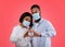 Valentine`s Day and coronavirus. Black couple making heart with hands, wearing protective masks on pink background