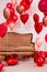 Valentine`s day decoration - group of red heart shaped balloons and vintage sofa over white wall