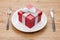 Valentine\'s day gift box on plate and silverware