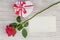 Valentine`s Day gift, rose and paper on wooden background.