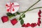 Valentine`s Day gift, roses and paper on wooden background.