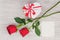Valentine`s Day gift, roses and paper on wooden background.