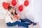 Valentine`s day, a guy kisses a beautiful girl who is holding a big red heart