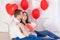 Valentine`s day, a guy kisses a beautiful girl who is holding a big red heart