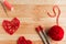 Valentine`s Day Handmade Red Thread Hearts and needlework supplies on wooden background.