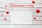 Valentine`s day lettering and postcards on red threads surrounded by hearts on wooden white background