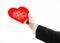 Valentine\'s Day and love theme: man\'s hand in a black suit holding a card in the form of a red heart