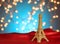 Valentine`s Day in Paris. Christmas, New Year in Paris. Golden Eiffel Tower on bright red satin. Blurred Xmas lights background.