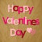 Valentine`s Day postcard pink Letters with Hearts on a crumpled paper brown background.