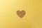 Valentine`s Day postcard. Wooden heart on yellow background. Copy space