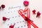 Valentine`s Day. A red heart-shaped ribbon highlights the date February 14 on a calendar sheet and dried flowers on a pink