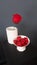 Valentine`s Day, red rose in a white vase, lots of hearts in a white vase, gray on a black background.