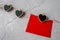 On Valentine's Day, a red sheet of paper hangs on a string of pins with black hearts on a gray background to
