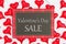 Valentine`s Day Sale message on hanging sign with red hearts on white fabric