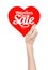 Valentine\'s Day and sale topic: Hand holding a card in the form of a red heart with the word Sale isolated on white background