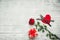 Valentine`s day table setting with fork, knife, red hearts, ribbon and roses.