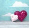 Valentine`s Day two shiny hearts on painted sky background