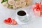 Valentine`s day. Wedding, mother`s day. A Cup of coffee and two gingerbread heart on a background of flowers and gifts
