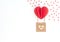 Valentine`s Day white background with red heart balloon with basket with wooden heart on it and lots of red hearts. Valentine