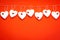 Valentine`s Day. White wooden hearts on a red background and red ladybugs. Blank for the designer. Valentines day concept.