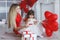 Valentine`s Day - young mother and little daughter in a room on the floor with gifts on a background of red heart-shaped balloons