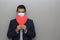 Valentine`s new normal. Formal Latin man with blue jacket, clinical use mask and red heart.