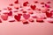 Valentine week Background of a collection of red and pink paper hearts arranged at the bottom of a light pink background.