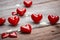 Valentine week Background of images of glossy red heart-shaped objects on a wooden background with white paint.