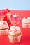 Valentines cupcake cream cheese frosting decorated with heart candy lollipop and gift box on the background.
