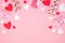 Valentines Day arched border of heart decorations over a pink background