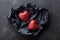 Valentines day background with pair of shiny heart in black paper from above.