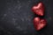 Valentines day background with pair of shiny heart on black table from above.