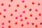 Valentines Day background. Pattern of paper confetti in shape of heart different colors on pink background. Festive composition.