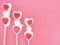 Valentines day background with three red and white lollipop Candy on pink