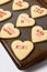 Valentines Day Concept: Closeup of Heart shaped sugar cookies on baking sheet with different sayings written in icing