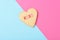 Valentines Day Concept: A Heart shaped sugar cookie on pink and blue with XOXO written in pink and red icing, and copy space