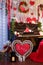 Valentines Day concept. Piano decorated with candles, red wooden hearts and flowers. Chair with red plaid